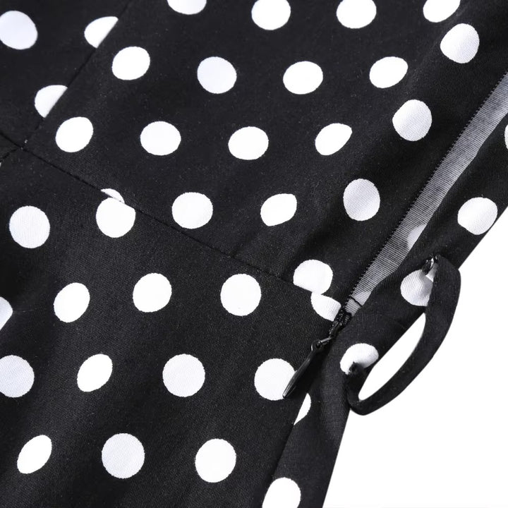 Close-up of black polka dot fabric showcasing white polka dots on a vintage swing dress for a classic look.