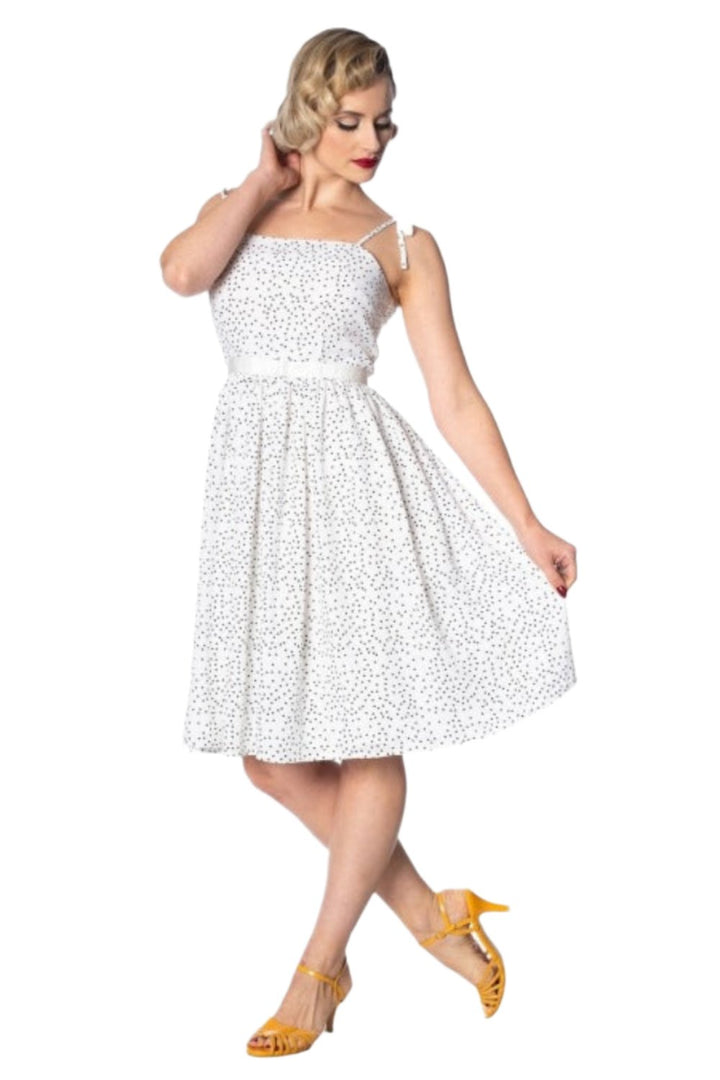 Sweet Spot Strappy Dress in white with polka dots, featuring spaghetti straps and a fitted silhouette, styled with yellow heels.