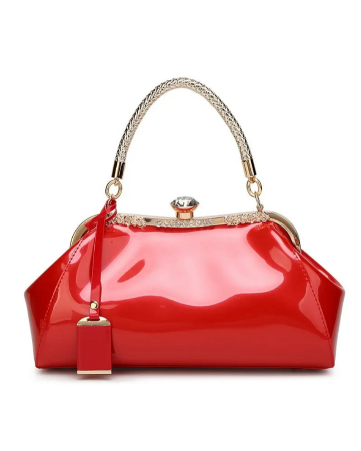 Red patent women's handbag with rhinestone clasp and elegant handle for a chic accessory collection.