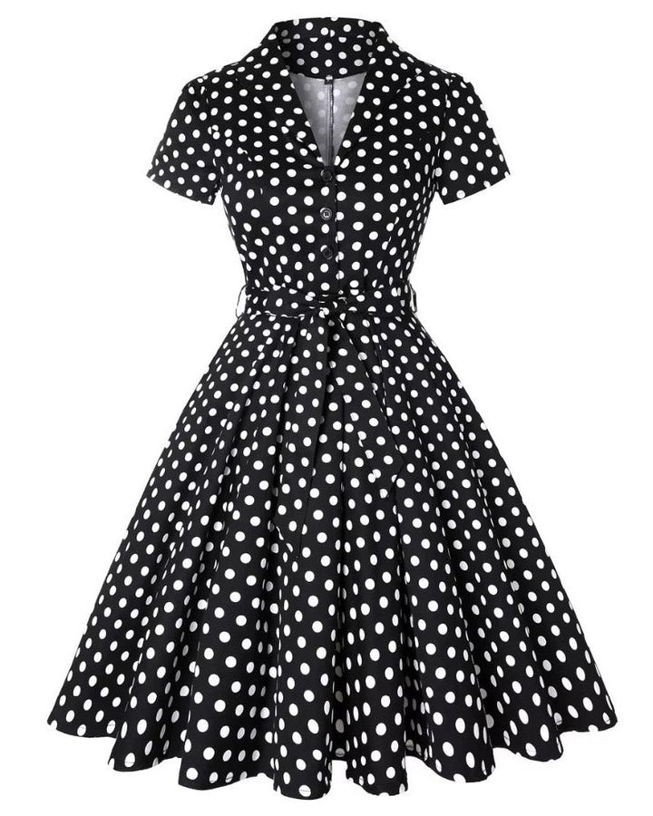 Black polka dot vintage swing dress with A-line silhouette and belt, offering classic elegance and playful charm.