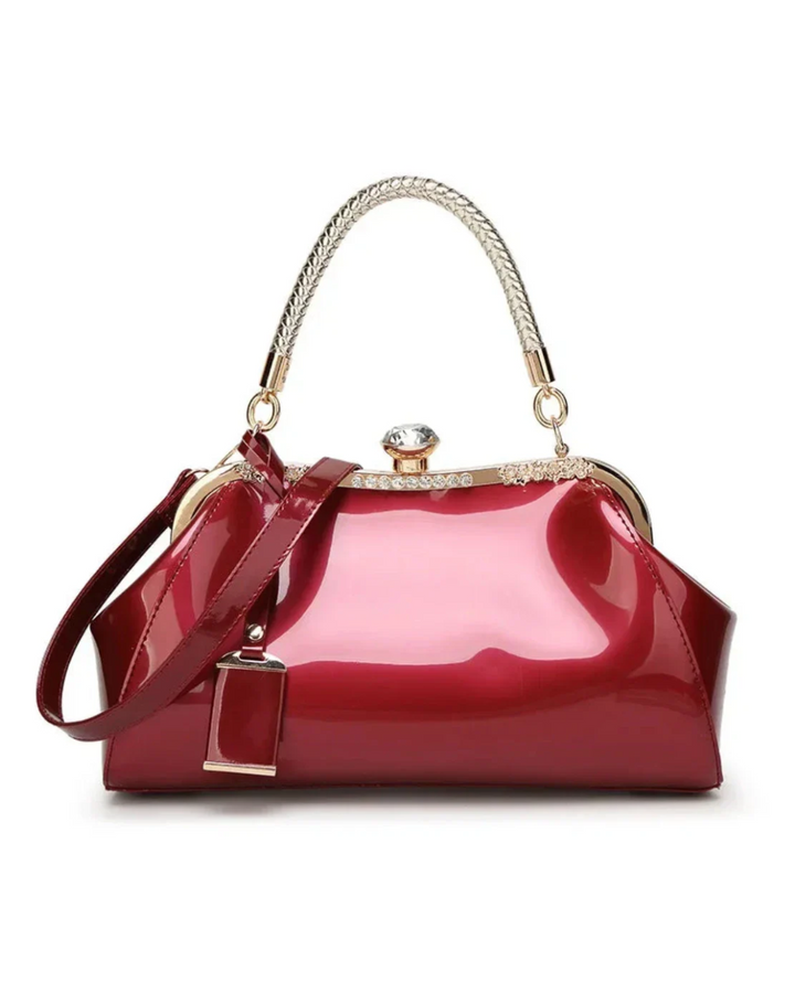 Burgundy patent women's handbag with braided handle and rhinestone lock, adding a bold and sophisticated touch to any outfit.