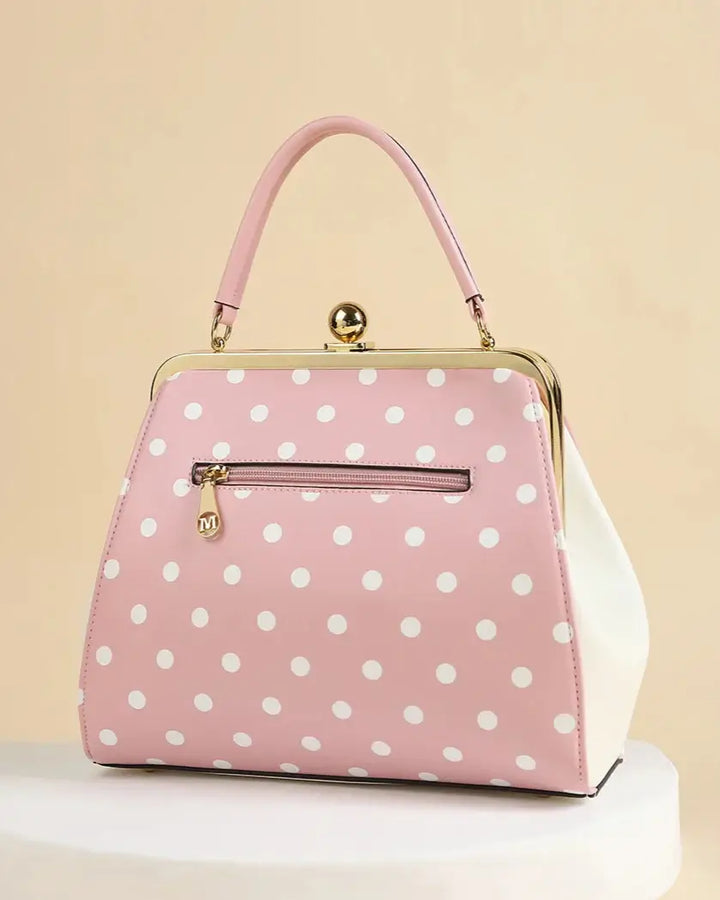 Pink polka dot rockabilly handbag with kiss-lock closure and adjustable handle, perfect for retro outfits.