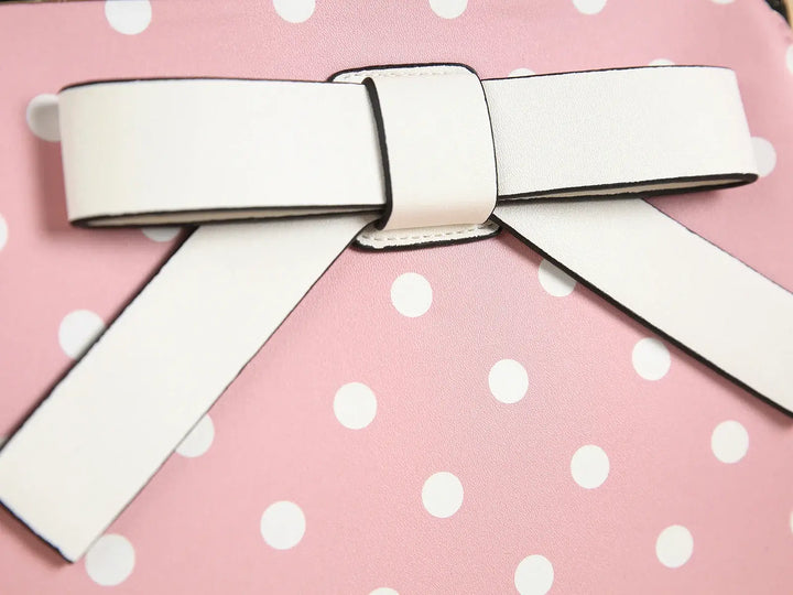 Close-up of a pink polka dot handbag featuring a vintage-inspired bow detail.