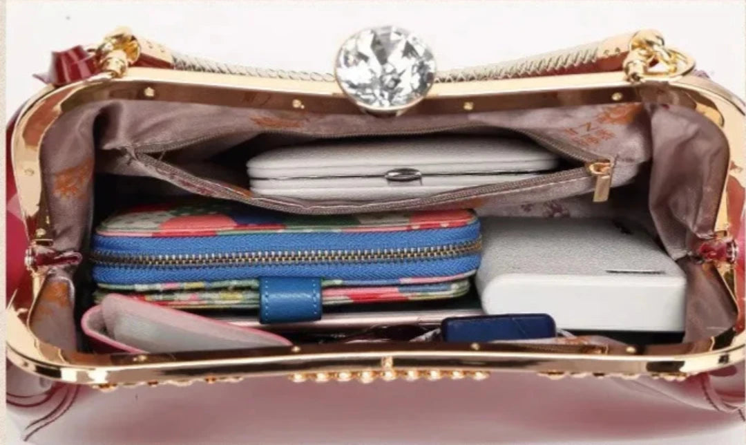 Interior view of burgundy patent women's handbag showing multiple organized items like wallets and a phone.