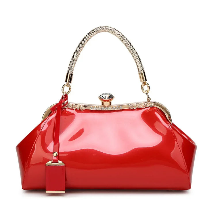 Red patent women's handbag with elegant rhinestone lock and braided handle, perfect for adding a bold touch to any outfit.