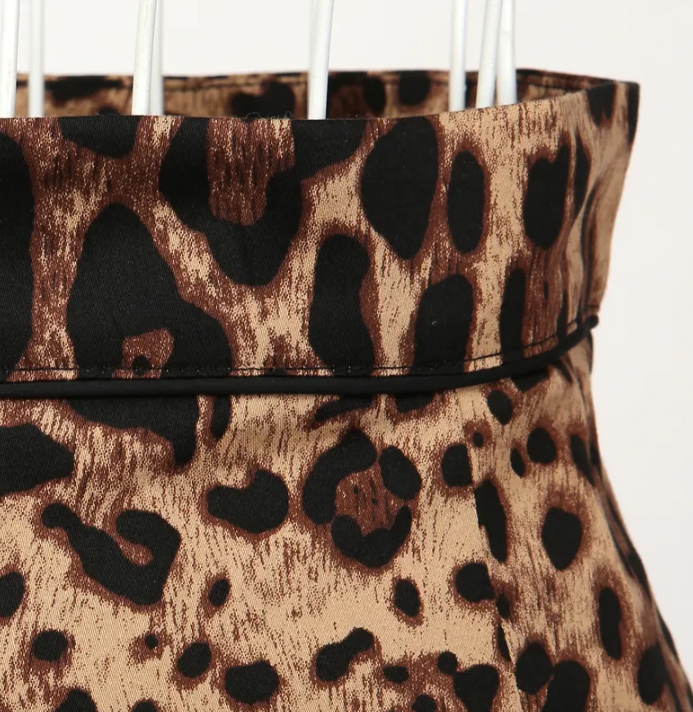 Close-up of the waistband of a leopard print pencil skirt, showcasing the bold fabric and stylish design.