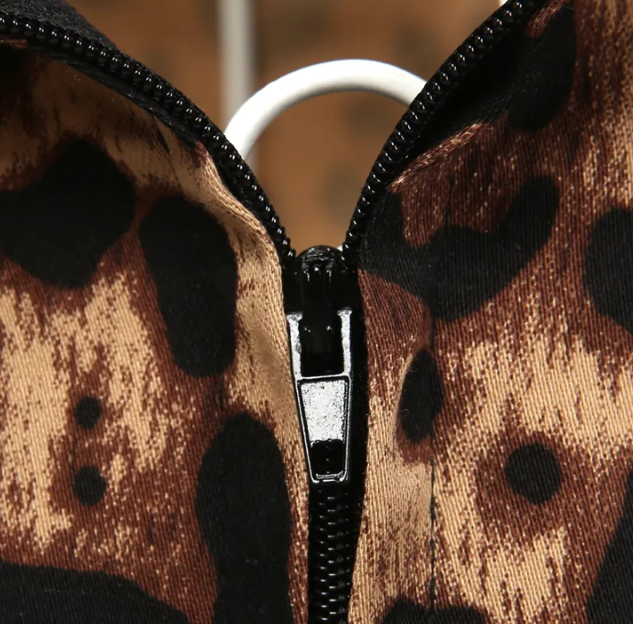 Close-up of leopard print fabric and zipper detail on a stylish pencil skirt, showcasing luxury and elegance.