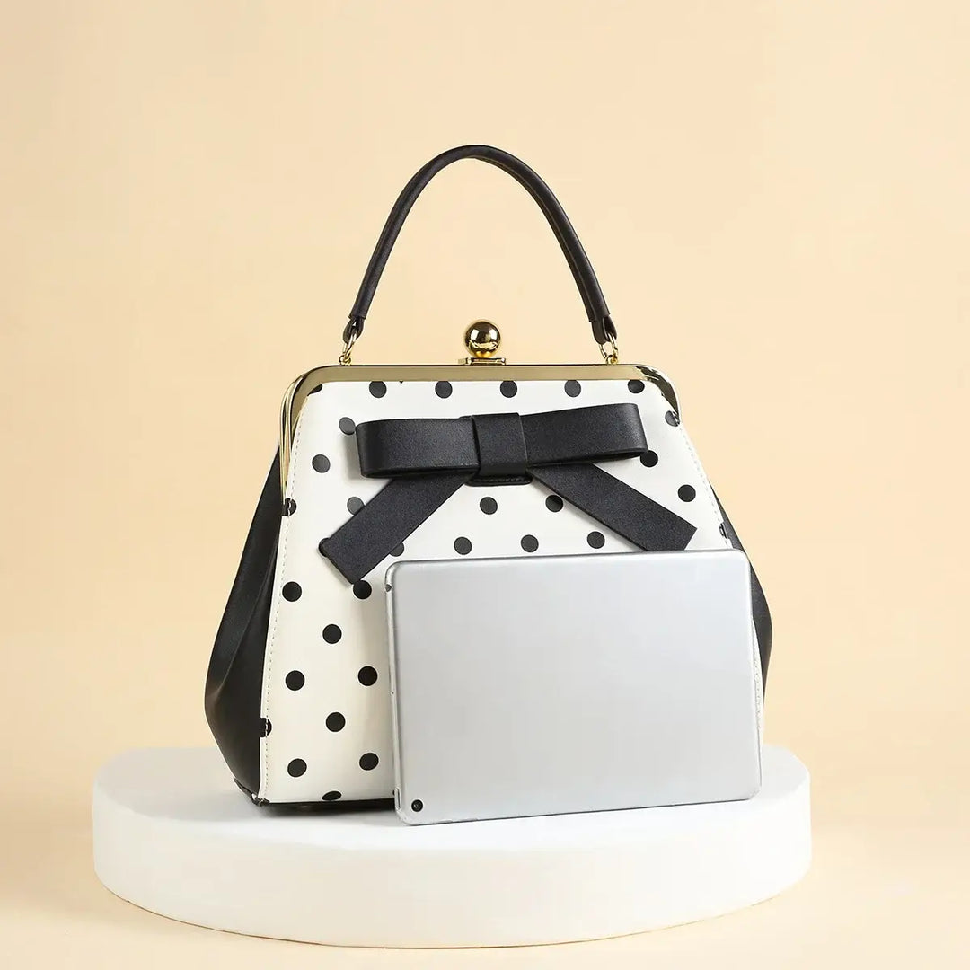 Black polka dot rockabilly handbag with bow detail, perfectly styled for a retro look.