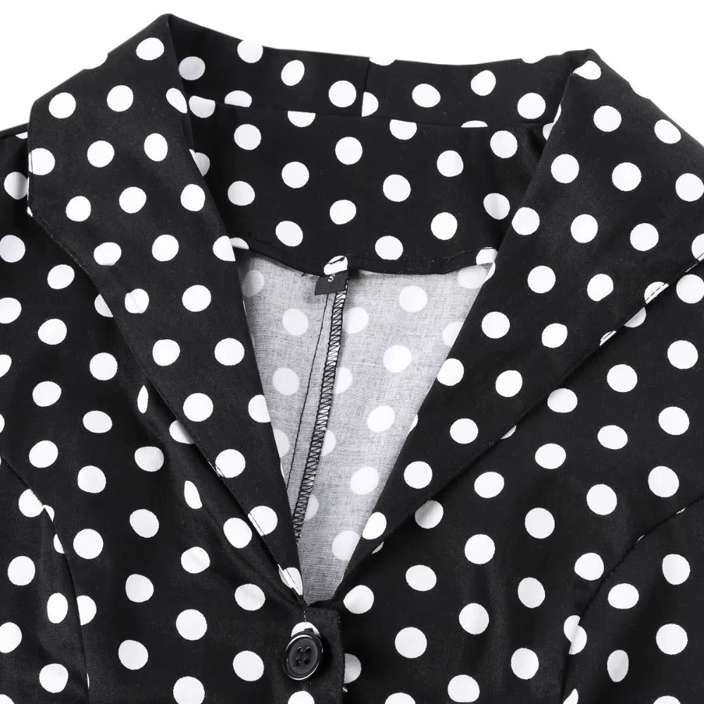 Close-up of the collar and button detail on a black polka dot vintage swing dress, showcasing its classic style.