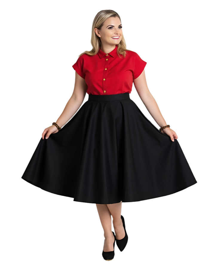 Woman wearing a red shirt and black full circle skirt, showcasing classic style and elegance.