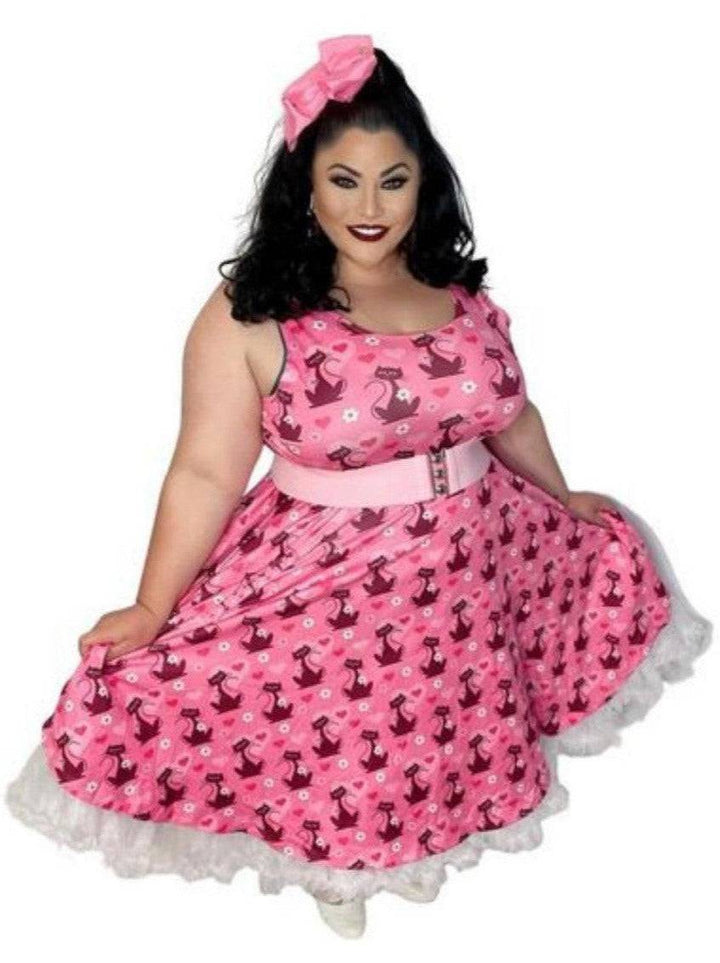 Model showcasing a retro pink skater dress with cat prints and a flared skirt, perfect for a chic, vintage-inspired look.