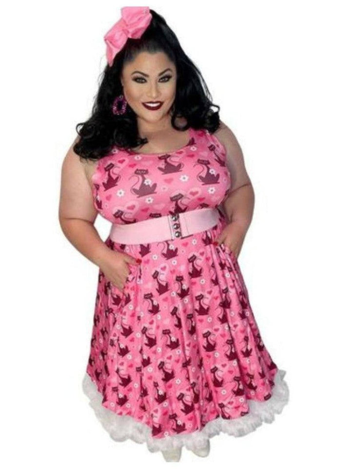 Retro pink skater dress featuring cat print, pockets, and a flattering fit-and-flare silhouette, styled with a bow.