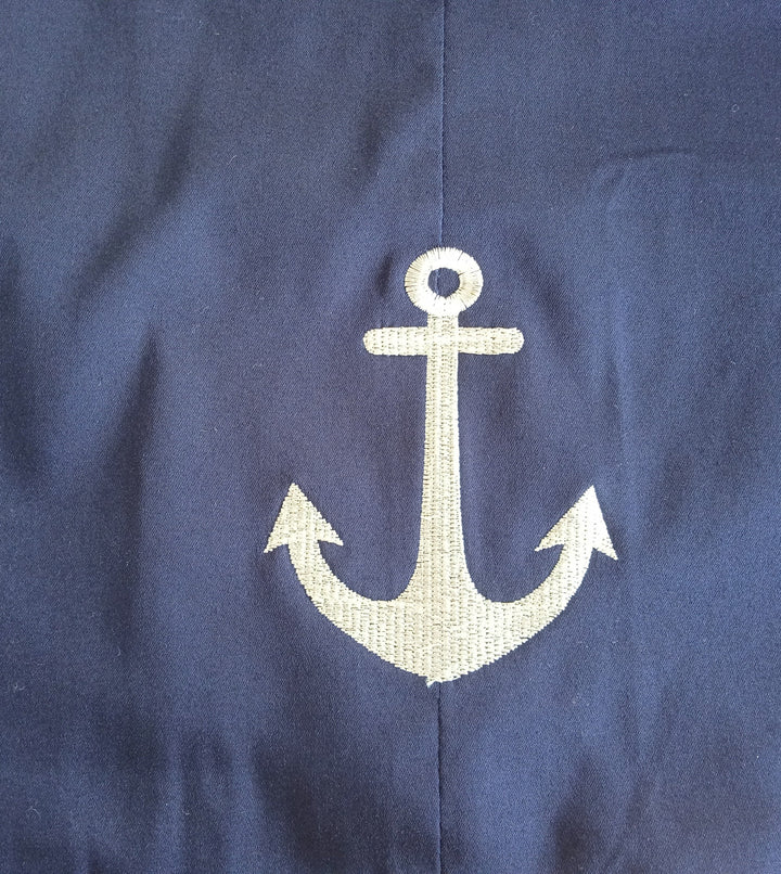 Navy fabric featuring a classic embroidered anchor design in a nautical theme.